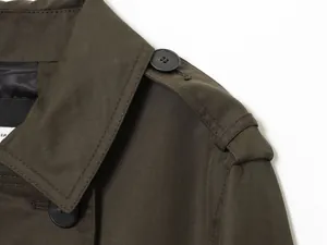Détail montrant la texture du tissu d'une épaulette de trench-coat vert olive de haute qualité