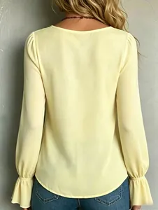 Rear view of an elegant light yellow long sleeve shirt featuring ruffled cuffs for women