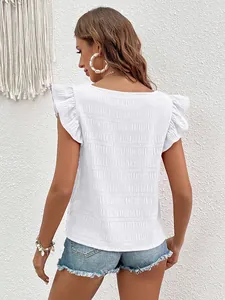 Back view of elegant white smocked blouse featuring flutter sleeves and textured fabric