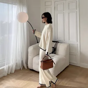 Elegant cream two-piece knit set featuring contrast black trim and high-waist wide-leg pants