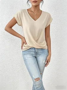 Detail view of elegant beige V-neck short sleeve top with hem twist detail