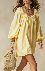 Gros plan d'une robe courte bohème jaune montrant des manches lanterne et un col froncé