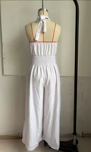 Detailed back view of a white bohemian backless wide-leg jumpsuit with smocked waist detail