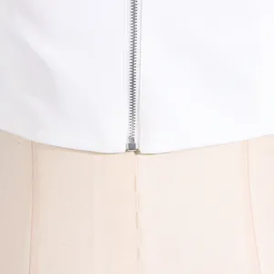 Close-up detail of the durable silver metal zipper on a white camisole top fabric
