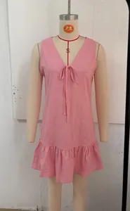 Detailed view of a pink sleeveless V-neck vacation dress featuring a charming ruffle hem