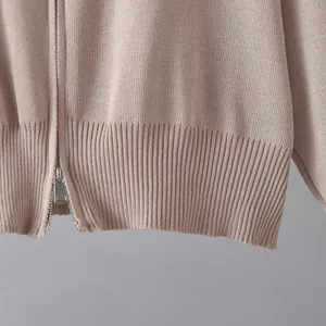 Detailaufnahme des Rippsaums und Metallreißverschlusses einer weichen Strickjacke für Damen