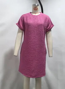 Close-up of magenta short-sleeved dress with textured crinkle fabric and round neck.