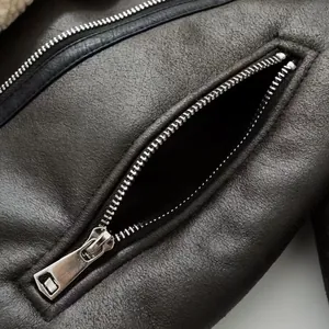 Close-up view showing the premium metallic zipper detail on a women's shearling biker jacket
