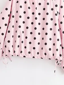 Close-up detail of a pink polka dot jacket featuring an adjustable drawstring hemline.