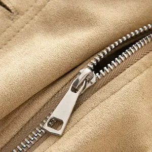 Macro detail of high-quality metal zipper on vintage brown suede jacket texture