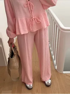 Elegant pink lantern sleeve tie-front top paired with wide-leg pants for a stylish lounge look