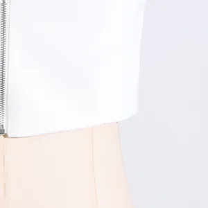 Close-up detail of white sleeveless top with functional metal zipper and clean fabric