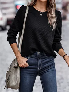 Detail view of black quilted sweatshirt featuring elegant puff sleeves and round neck