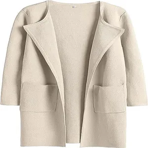 Dettaglio dell'elegante rever e delle ampie tasche di questo cappotto in maglia beige.