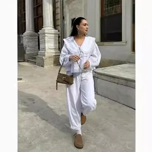 Κομψή λευκή μπλούζα με κολάρο κούκλας, δαντέλα και φουσκωτά μανίκια σε εξωτερικό χώρο