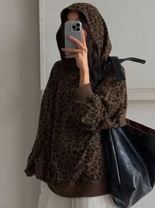 Woman in oversized retro leopard print corduroy hoodie with high street style vibe
