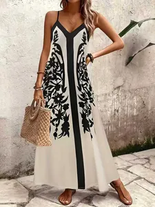 Vestido largo bohemio con estampado de hojas negras, finos tirantes y escote en V.