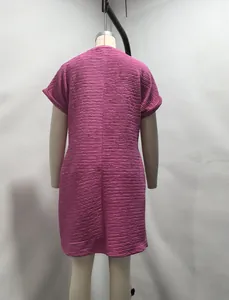 Back view of a pink short sleeve dress with textured pleated fabric and loose fit