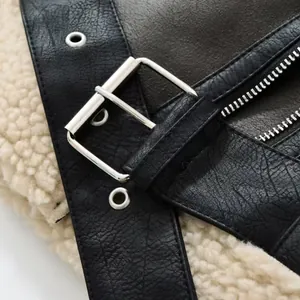 Macro detail of silver metal buckle and soft shearling lining on a black biker jacket