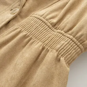 Close-up of faux suede jacket showing elastic waist detail and textured fabric.