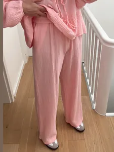 Detail view of a pink textured lounge set with tie-up top and wide-leg pants.