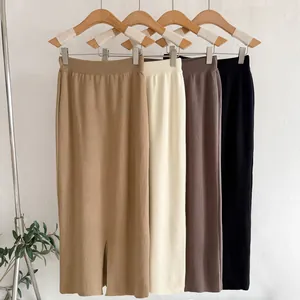 High-waist knitted midi skirts in multiple colors hanging on wooden hangers