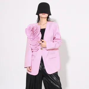 Detail van een roze damesblazer met een grote 3D-geplooide stoffen bloemdecoratie