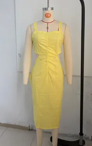 Dettaglio di un abito midi giallo arricciato con ritagli laterali su manichino