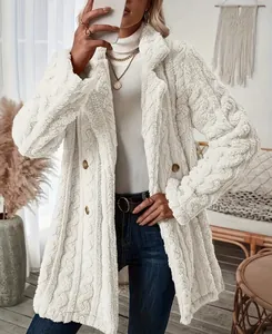 Détail d'un manteau en fausse fourrure blanche avec boutons à double boutonnage.
