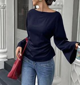 Detail shot of navy boat neck top with gathered waist and elegant flared sleeves.