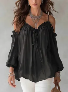Elegant detail of black ruffled off-the-shoulder blouse featuring tie-front and loose fit