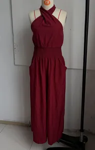 Detail of a burgundy halter wide-leg jumpsuit featuring smocked waist on a mannequin