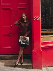 Elegant French style brown knit dress with ruffle hem and lapel collar worn by model.