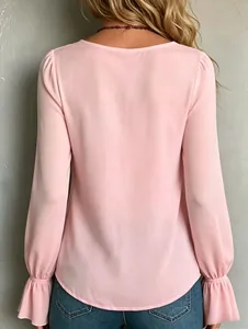 Rear view of an elegant pink long-sleeved blouse with feminine ruffled cuffs and smooth fabric