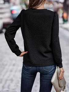 Back view detail of black quilted sweatshirt with puff sleeves and textured diamond pattern