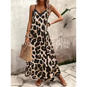 Modelo con un vestido largo bohemio de leopardo con tirantes finos en vacaciones.