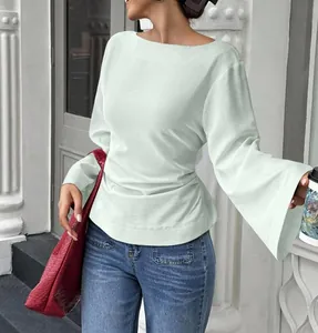 Detail view of the elegant boat neck and flared bell sleeves on a mint green knit top