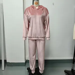 Detalle de un conjunto de dos piezas de terciopelo rosa con sudadera con capucha y pantalón