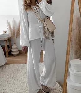 Detailed view of white crinkle fabric two-piece set with lace-up top and matching wide trousers