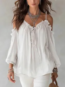 Detailed shot of white ruffled off-the-shoulder blouse with thin spaghetti straps