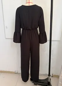 Back view of a black long-sleeved wide-leg jumpsuit with bell sleeves on a mannequin.