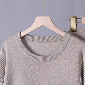 Close-up view of a premium neutral knit round-neck top with fine ribbed collar details