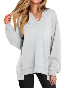 Detailopname van de textuur en de V-hals van een lichtgrijs losvallend sweatshirt