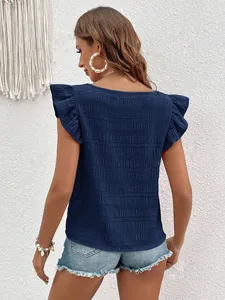 Detail view of navy blue blouse with ruffle sleeves and textured shirred fabric back