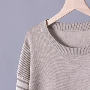 Detailed macro view of beige knitted sweater neckline and striped sleeve texture pattern
