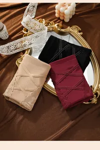 Detailed view of mid-waist seamless tummy control panties in beige, burgundy, and black.