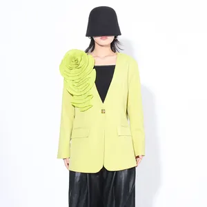 Detailweergave van de limoengroene blazer met geplooide bloemdecoratie voor dames