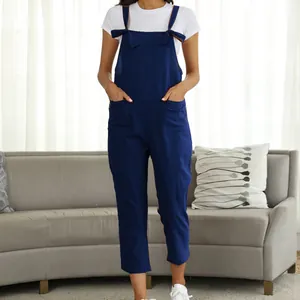 Front view of navy blue casual overalls jumpsuit in a bright living room setting