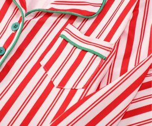 Detalle macro de pijama de Navidad a rayas rojas y blancas con bolsillo y ribete verde