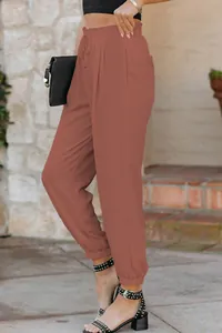 Side view detail of terracotta high-waisted joggers with drawstring and elastic cuffs.